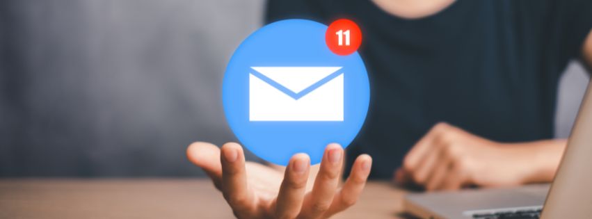 Osoba trzymająca unoszącą się ikonę wiadomości e-mail z powiadomieniem – symbol nowoczesnego e-mail marketingu.